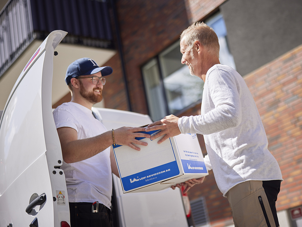 En hantverkare tar emot ett paket av en budbilsleverantör
